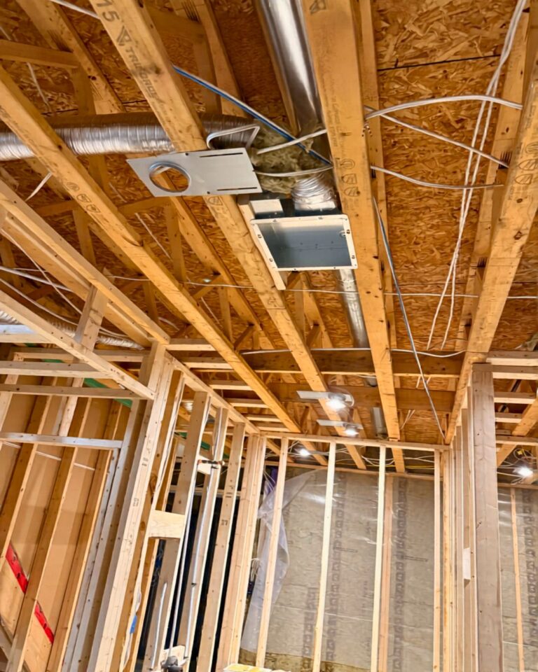 Bathroom renovation at rough-in, with the fan and wiring in open framing