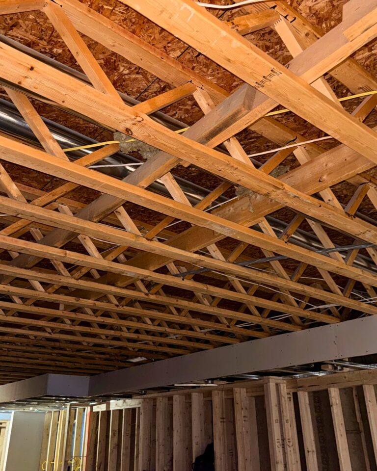 Living room renovation at electrical rough-in, with open ceiling joists