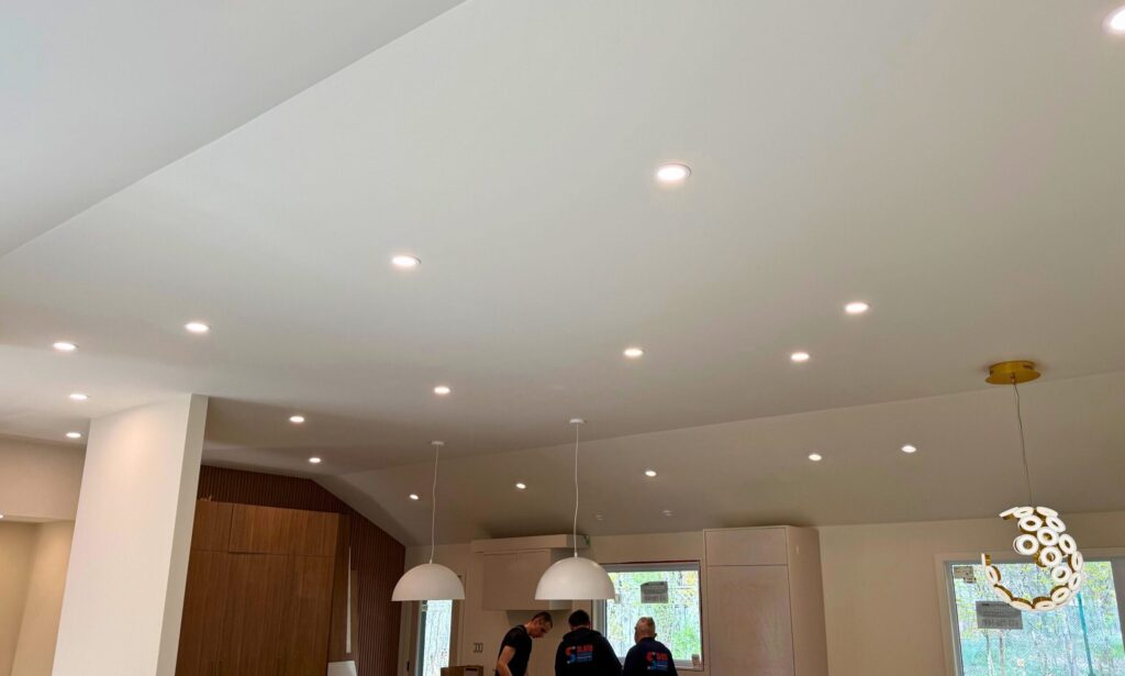 Pot lights and pendant lights installed in a finished room